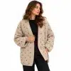 Woman wearing a beige open-front wool cardigan with brown polka dots